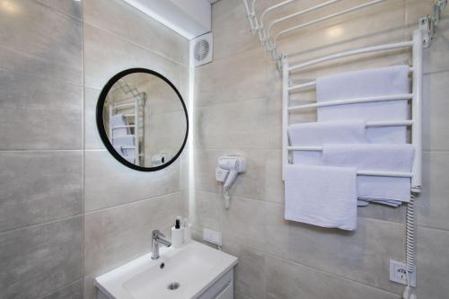 a bathroom with a sink and a mirror and towels at CityApartments Kyiv Vokzalna in Kyiv