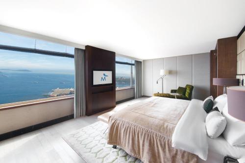 a bedroom with a large bed and a large window at The Marmara Taksim in Istanbul