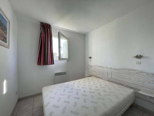 une chambre blanche avec un lit et une fenêtre dans l'établissement Maison duplex avec clim, 2 piscines, terrasse, parking, animaux admis - 8 pers. - FR-1-382-165, à Salavas
