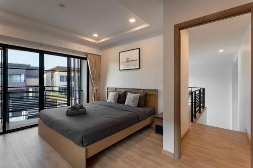 a bedroom with a large bed and a balcony at Kanna Pool Villa in Chiang Mai