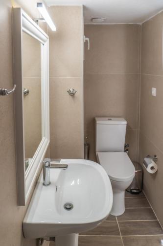 a bathroom with a white sink and a toilet at Seaside Escape by Infinity in Nea Kallikrateia