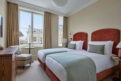 a hotel room with two beds and a window at Miiro Templeton Garden in London