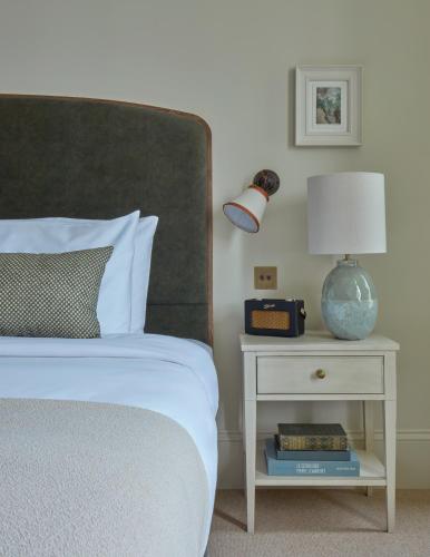 a bedroom with a bed and a nightstand with a lamp at Miiro Templeton Garden in London