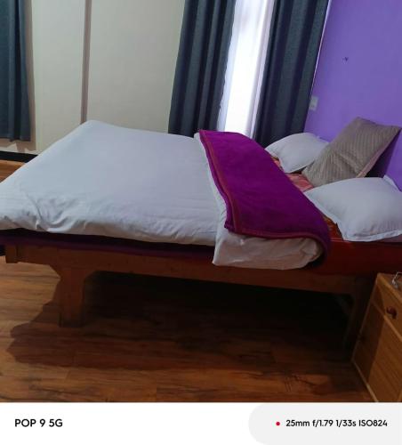 a bed with white sheets and pillows on it at SALCHAN INN Home Stay in Takh