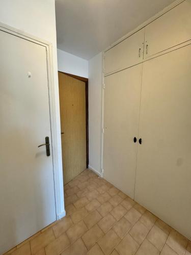 une pièce vide avec des armoires blanches et une porte dans l'établissement Studio cosy au cœur de Propriano, à Propriano