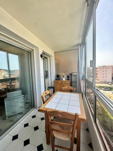 une table et des chaises dans une pièce avec une grande fenêtre dans l'établissement Studio cosy au cœur de Propriano, à Propriano