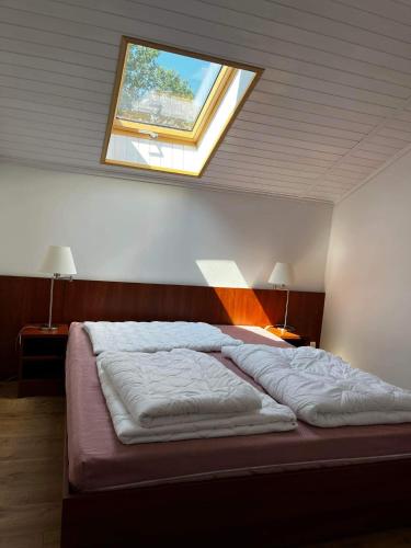 a bedroom with a bed with a window on the ceiling at PontyParádé in Fonyód
