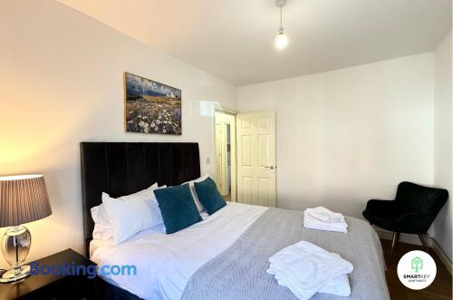 a bedroom with a large bed with a black headboard at Ground Floor 1 Bedroom Apartment close to Woking train station in Woking
