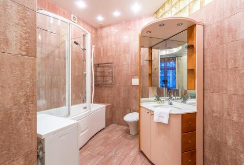 a bathroom with a tub and a toilet and a sink at Cheap Apartments in Kyiv