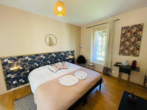 a bedroom with a bed with two white plates on it at Domaine Jeanne de Laval in La Bohalle