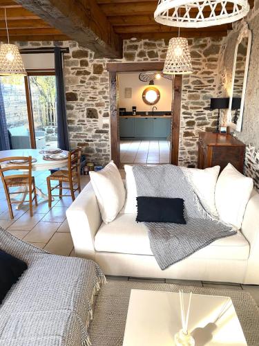 un salon avec un canapé blanc et une table dans l'établissement Le cottage de Zoé, au Vivier-sur-Mer
