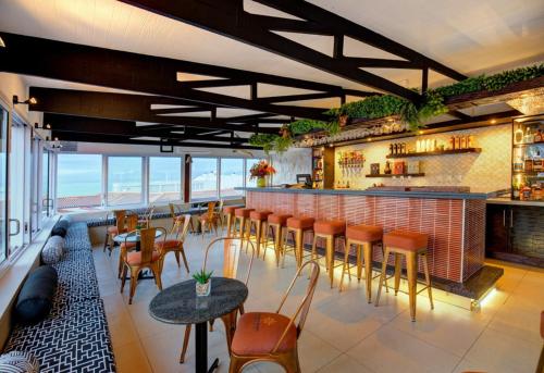 a restaurant with a bar with chairs and tables at Protea Hotel by Marriott Mossel Bay in Mossel Bay