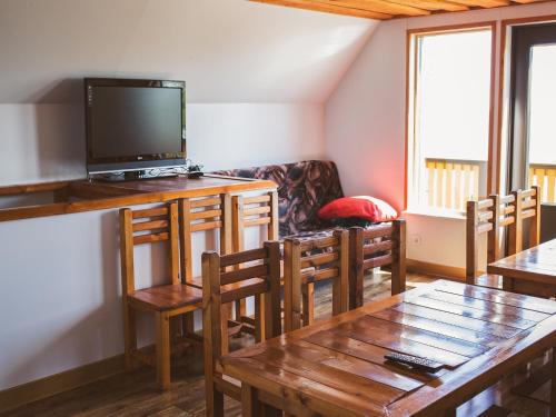a living room with a tv and a table and chairs at Pusi Holiday House in Pusi