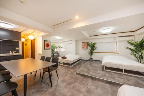 a room with two beds and a table and chairs at R201-Shinjuku 13 min Up to 8 people 60 sqm Full renovation Roppongi and Tsukiji direct access Family group 7 min to Ochiai Minami Nagasaki Station in Tokyo