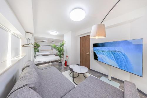a living room with a couch and a big screen tv at R201-Shinjuku 13 min Up to 8 people 60 sqm Full renovation Roppongi and Tsukiji direct access Family group 7 min to Ochiai Minami Nagasaki Station in Tokyo