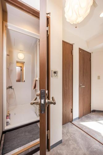 a bathroom with a walk in shower next to a door at R201-Shinjuku 13 min Up to 8 people 60 sqm Full renovation Roppongi and Tsukiji direct access Family group 7 min to Ochiai Minami Nagasaki Station in Tokyo