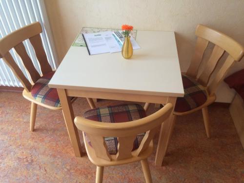 a table with two chairs and a vase of flowers on it at Pension Hönel-Hof Bad Schandau in Bad Schandau
