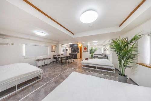 a large room with two beds and a table at R201-Shinjuku 13 min Up to 8 people 60 sqm Full renovation Roppongi and Tsukiji direct access Family group 7 min to Ochiai Minami Nagasaki Station in Tokyo