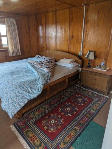 a bedroom with a bed and a sink and a rug at Lukla Himalaya Lodge in Lukla