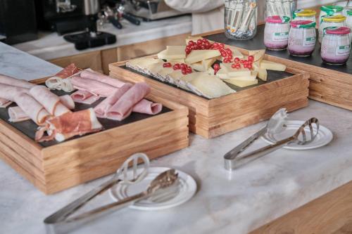 a counter with two trays of meats and cheese at Elysée Montmartre Hotel in Paris
