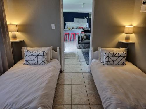 two beds in a room with a living room at Summerville Place in Addo