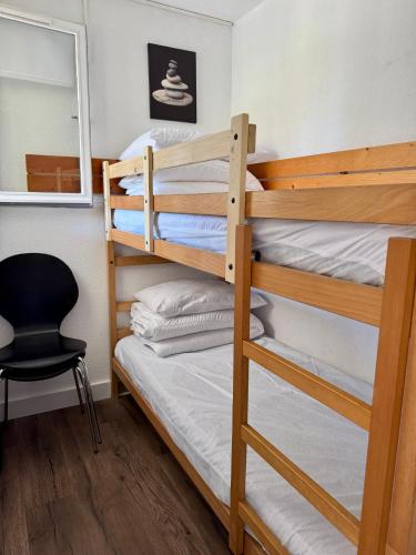 - une chambre avec 2 lits superposés et une chaise dans l'établissement L'ocre du Sud - 6 pers - Histoire de clés, au Cap d'Agde