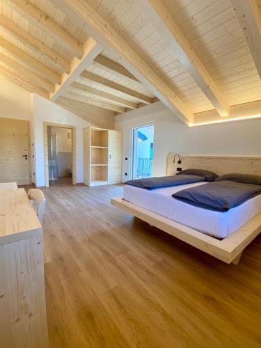 a large bedroom with a large bed and wooden floors at Agritur Casamela in Taio