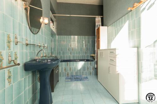 a bathroom with a sink and a tub at Ancienne ecole in Montbrun-Bocage