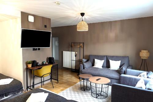 a living room with a couch and a tv at Hôtel Lodge In Paris 13 in Paris
