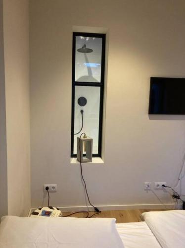 a bedroom with a window and a tv on the wall at Arbio I Lax Apartments in Leipzig
