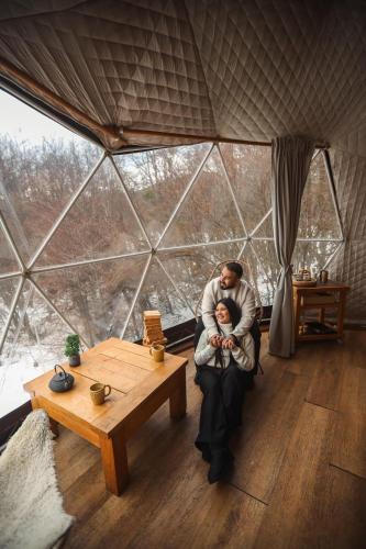 a man holding a baby in a room with a large window at DOMO en Ushuaia Glamping in Ushuaia