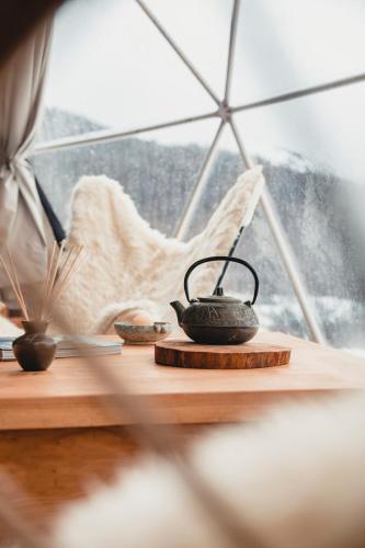 a tea kettle on a table in front of a window at DOMO en Ushuaia Glamping in Ushuaia