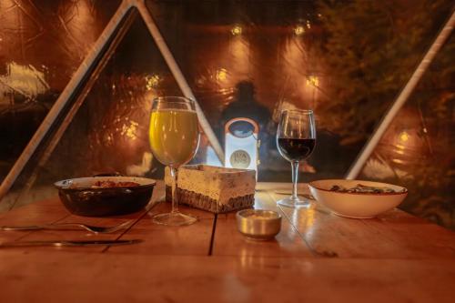 a table with two glasses of wine and a bottle of wine at DOMO en Ushuaia Glamping in Ushuaia