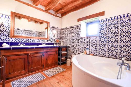 a bathroom with a tub and a sink and a mirror at Chez pailhas in Régades