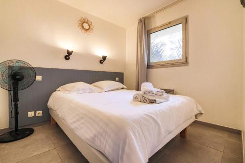 une chambre avec un lit avec des draps blancs et une fenêtre dans l'établissement Le Cannes Beach 161 - cosy, terrasse & piscine, à Cannes