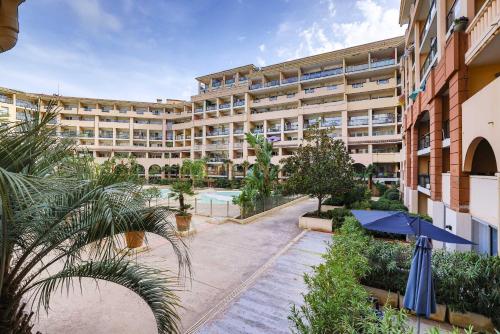 un immeuble d'appartements avec une cour ornée de plantes dans l'établissement Le Cannes Beach 161 - cosy, terrasse & piscine, à Cannes