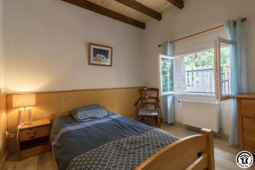 a bedroom with a bed and a window at La lande in Ponlat-Taillebourg