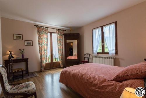ein Schlafzimmer mit Bett, Stuhl und Fenstern in der Unterkunft Gèze in Chein-Dessus