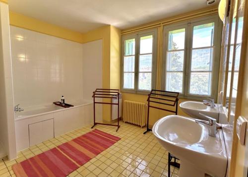 a bathroom with two sinks and a bath tub and a tubermott at Le clos saint-paul - nature in Estadens
