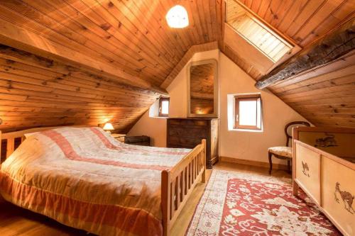 a bedroom with a large bed in a wooden ceiling at Près de l'eglise in Garin