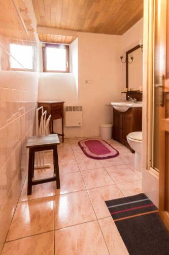 a bathroom with a chair and a sink and a toilet at Près de l'eglise in Garin