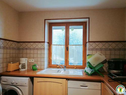 een keuken met een spoelbak en een raam bij Chez courrier in Razecueillé