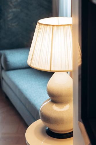 a lamp sitting on a table next to a couch at Maison Barrière Vendôme in Paris