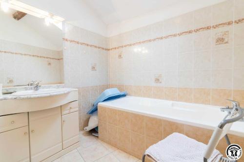 ein Badezimmer mit Badewanne und Waschbecken in der Unterkunft Panifous in Montbrun-Bocage