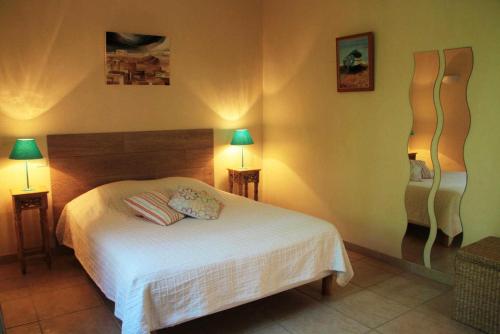 a bedroom with a white bed and two lamps at Le petit clot de pey in Esperce