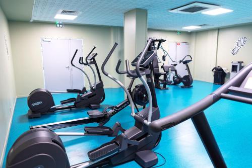 a gym with several tread machines in a room at Hôtel Lodge In Paris 13 in Paris