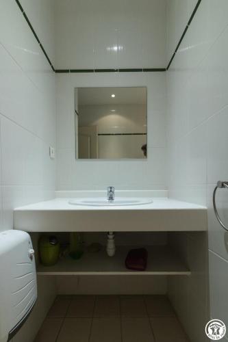 a white bathroom with a sink and a mirror at Granny in Pibrac