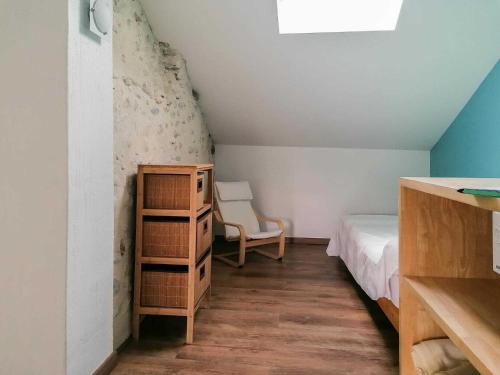 a small bedroom with a bed and a chair at Le gar in Labarthe-Rivière
