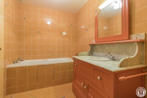 a bathroom with a sink and a tub and a mirror at Le clos saint-paul - comminges in Estadens