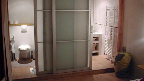 a glass door in a bathroom with a toilet at Baugnac in Lavalette